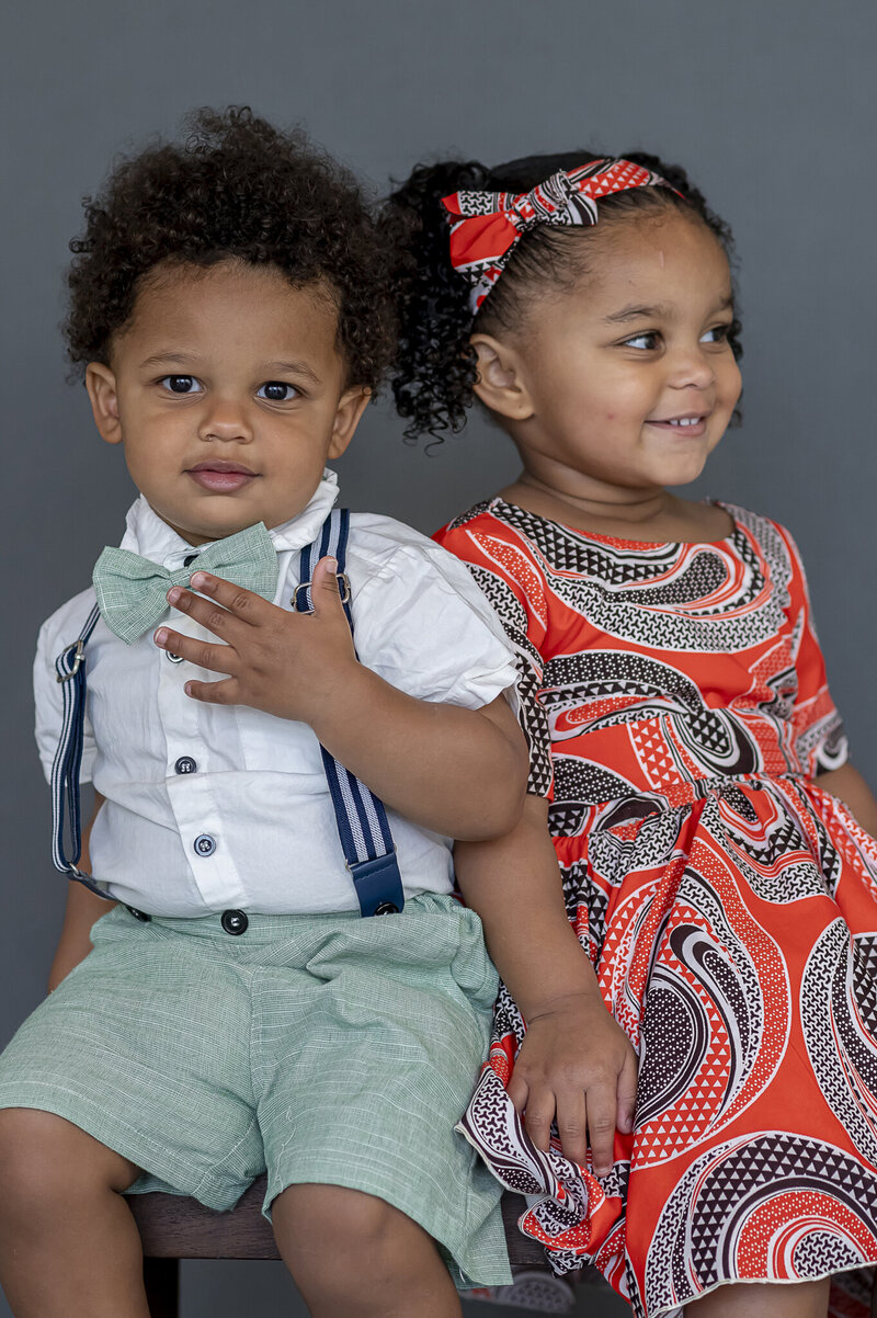 Brother and sister in colourful outifts sitting and smiling for the camera in Port Coquitlam, BC