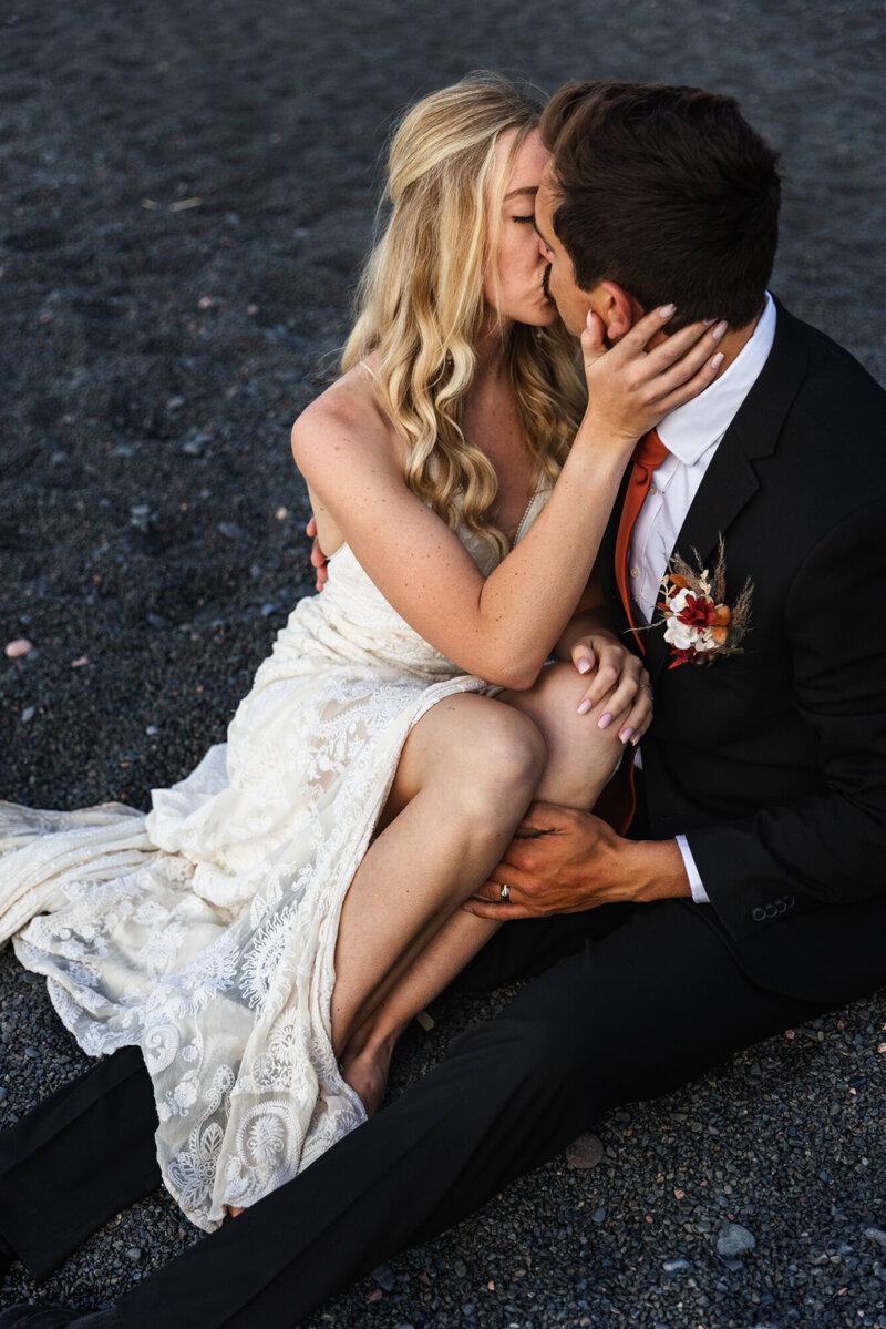 couple kissing on black beach in New Zealand taken by New Zealand elopement photographer Marcus Hanenburg Photography