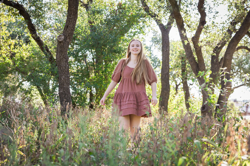 girl standing in tall grass