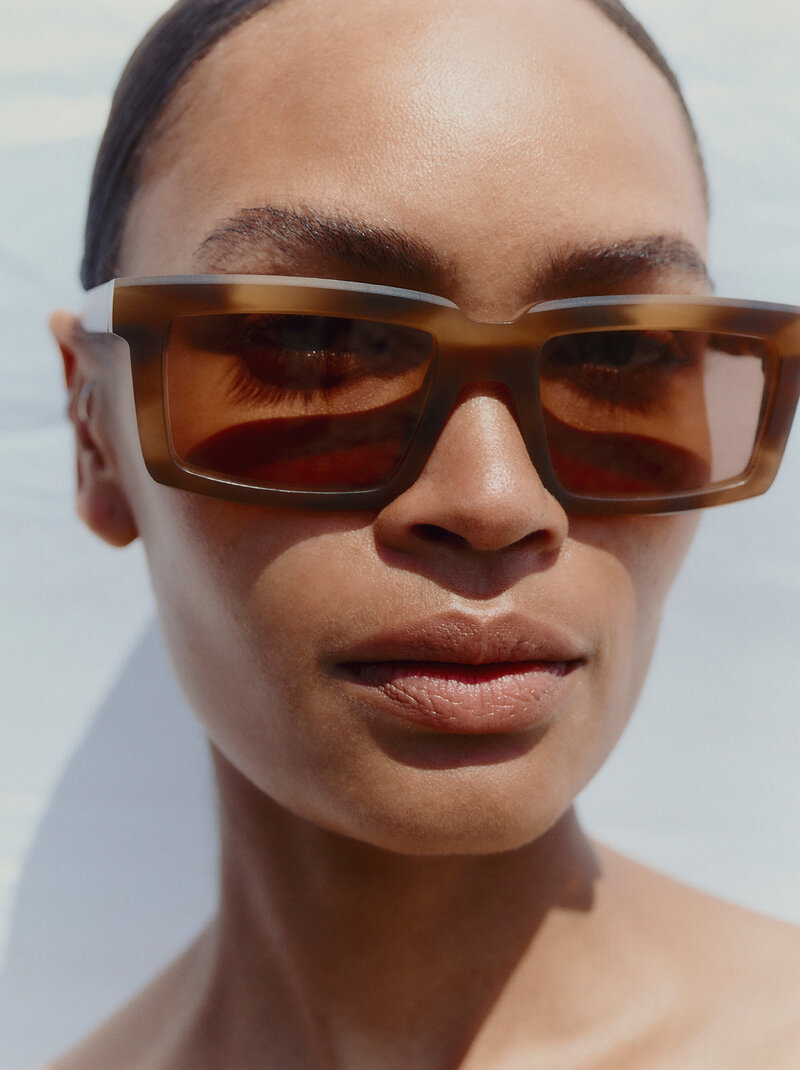 Close-up of a woman wearing MYKITA sunglasses, available at Colaizzo Opticians in Queen Anne, Seattle