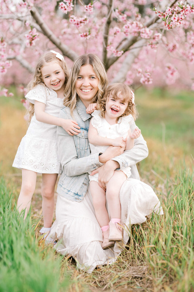 Niagara Wedding Photographer  with her daughters in a sherry Blossom field