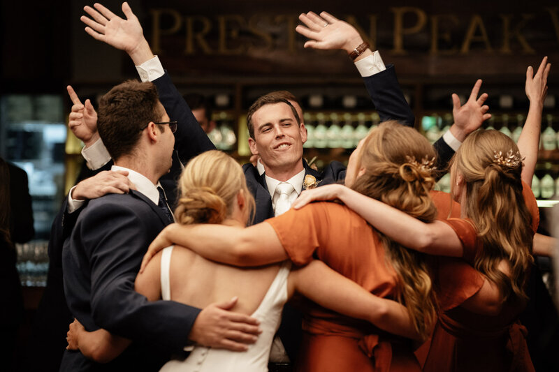 Wedding couple, groomsmen and bridesmaids all dance together