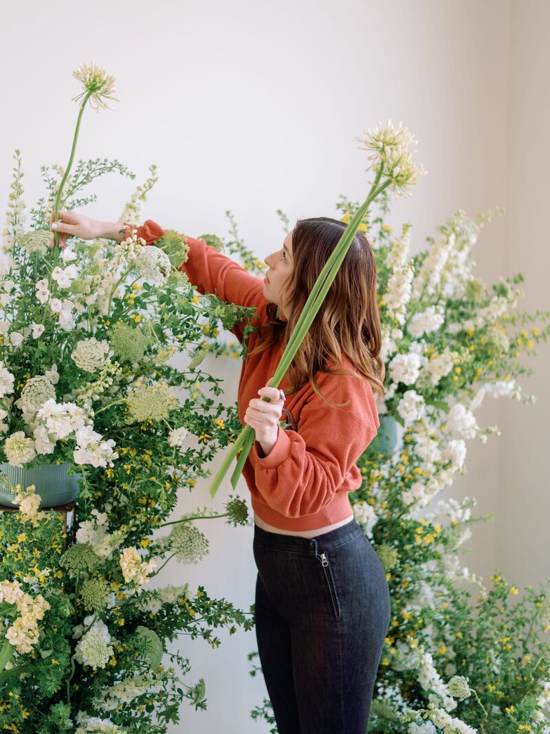 Jenny of Anthousai Florals in Tulsa arranging a large floral installation at Merrick Hollow