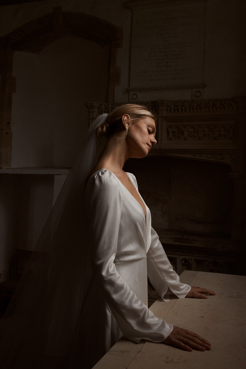 Long-sleeved wedding dress in silk worn by bride in chapel
