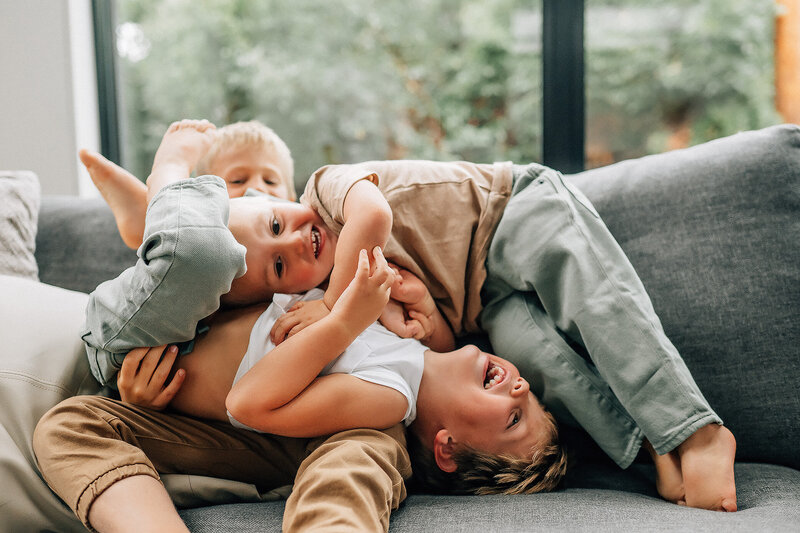 parents kissing while holding their son and daughter on dad's shoulders