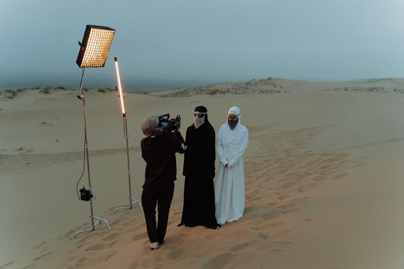 three men filming in the middle of the desert