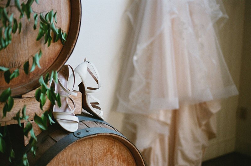 Shoes and wedding gown on top of barrels in Hideaway Cellars, Seattle.