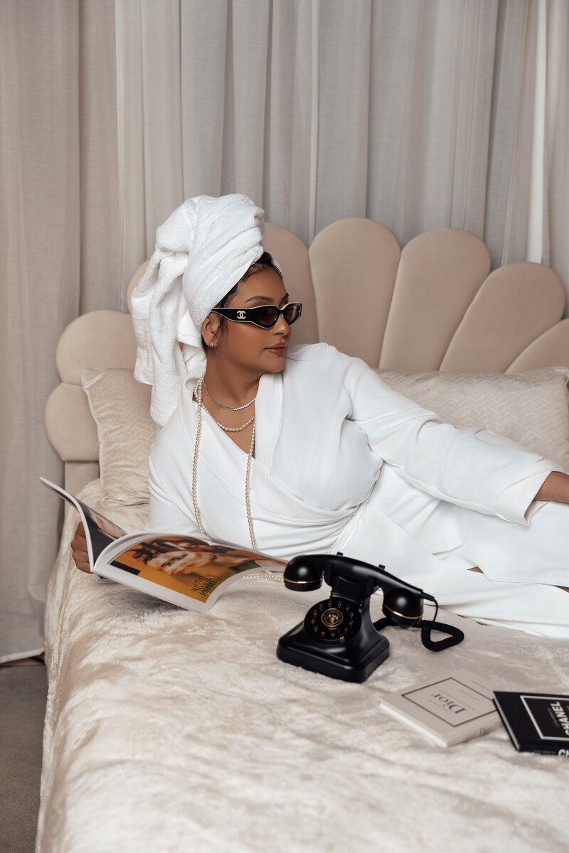 Bianca on bed with robe reading magazines