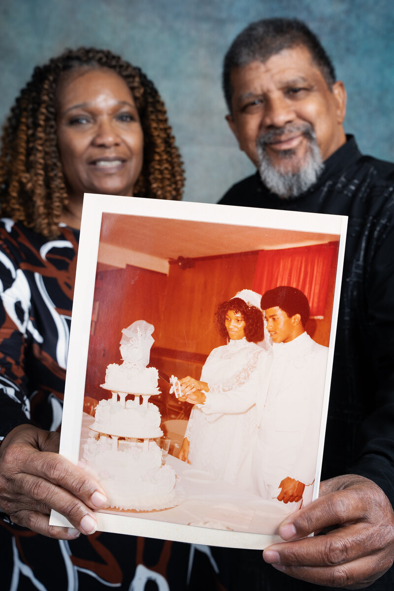 a photo of a middle-aged couple holding a polaroid from their wedding day