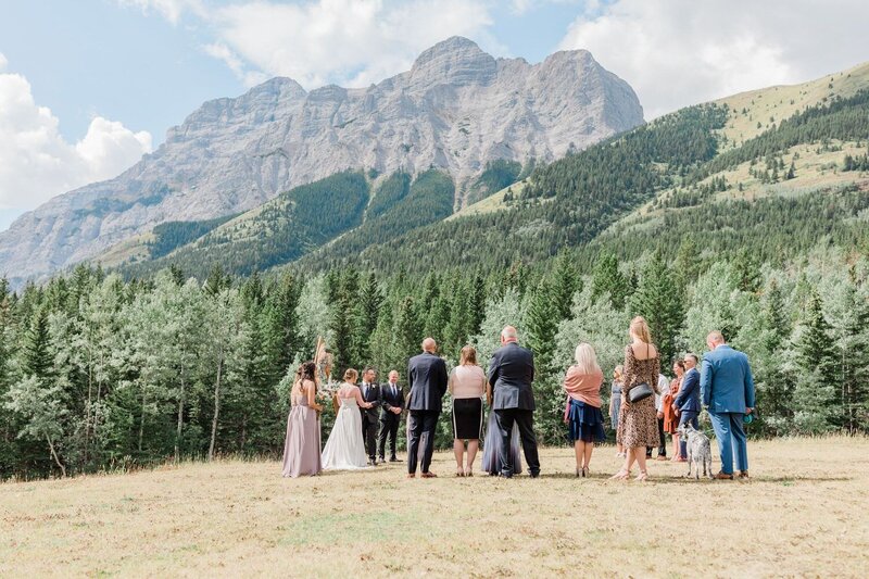 A stunning summer wedding ceremony at Pomeroy Kananaskis Mountain Lodge, featuring Mount Kidd as a breathtaking backdrop in the heart of Kananaskis Country.