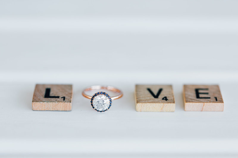 love spelled with scrabble letters and engagement ring
