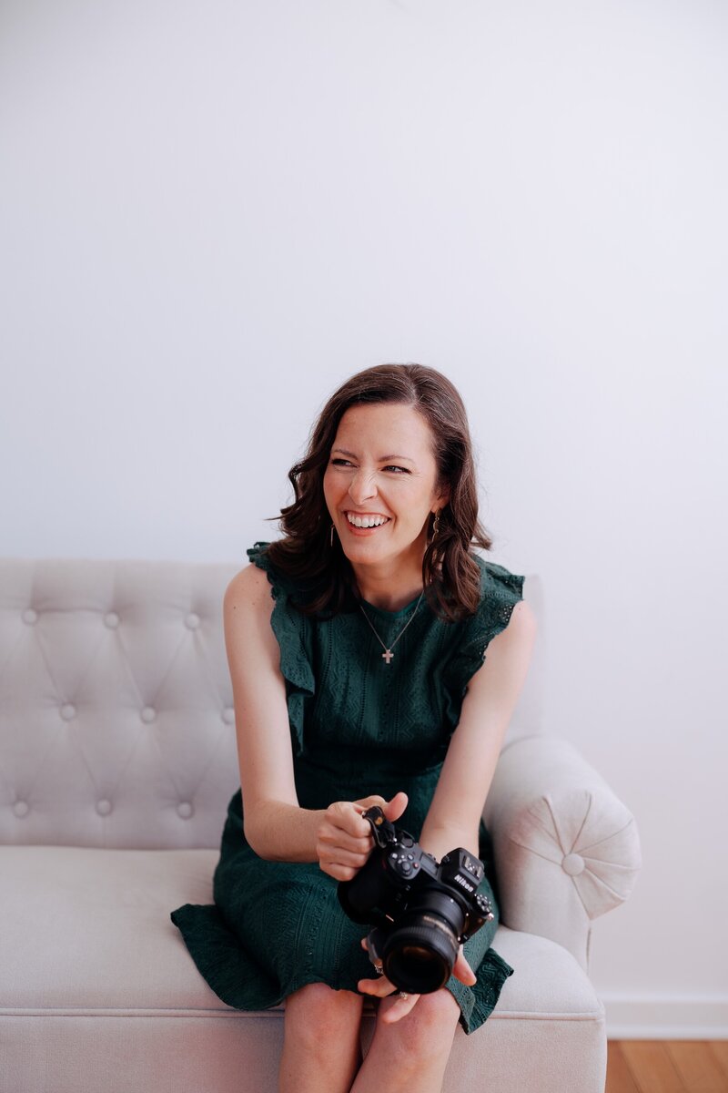 Carrie smiling while holding a camera