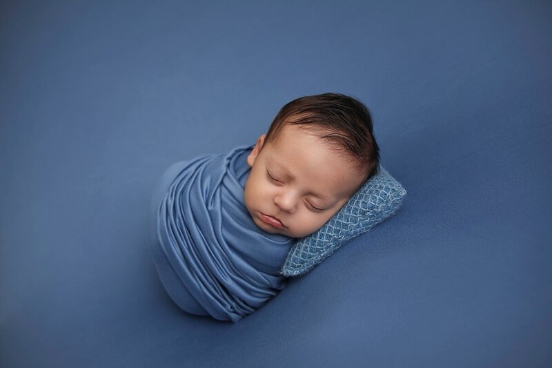 newborn boy in blue wrap