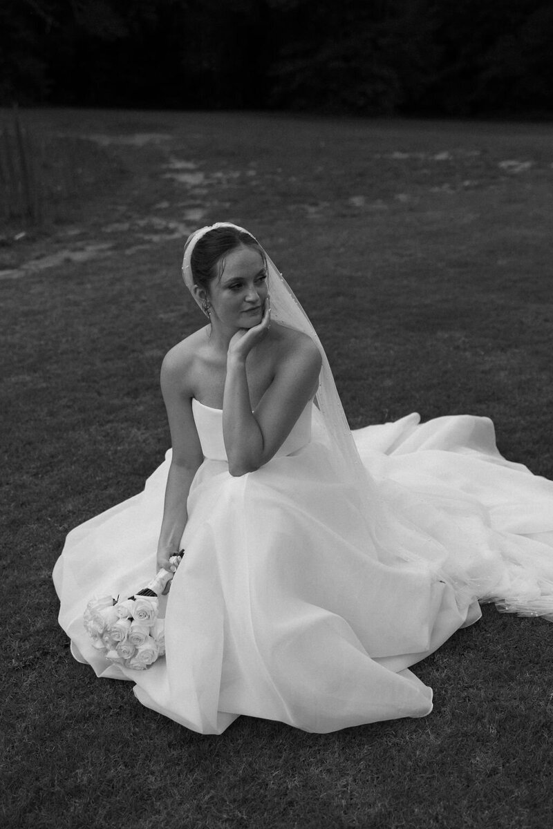 Bride kneeling in wedding dress at Daisy Hill Venue in Georgia.