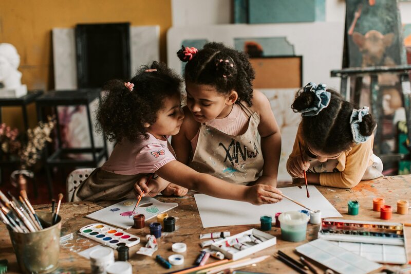 Children engaged in painting, symbolizing the whole-child and creative lens of gifted and twice exceptional assessments in Santa Barbara.