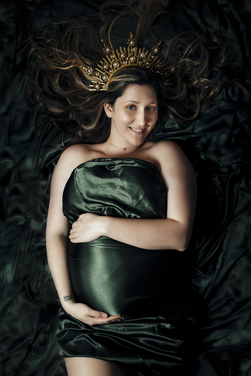A woman in black lace lingerie lays on a leopard print rug with a hand on her breast