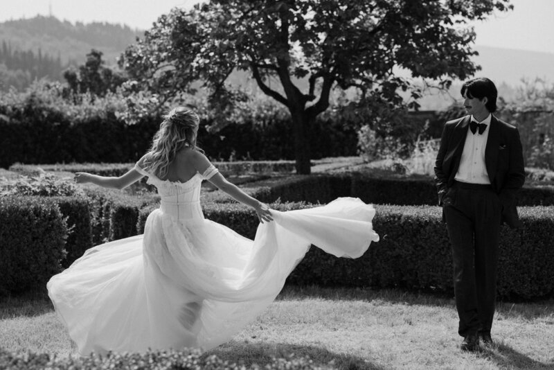 A person looking back at their partner as they spin in their wedding dress 