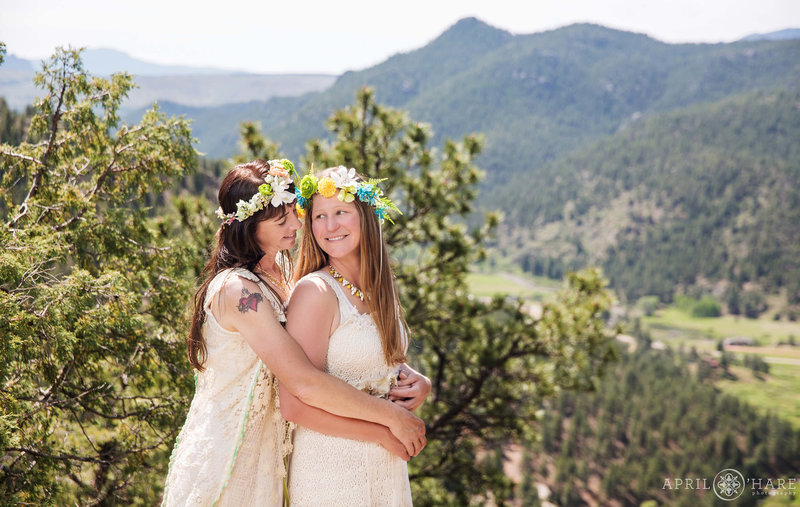 Pretty mountain backdrop for a wedding photo with two brides wearing flower crowns at Bucksnort Disc Golf in Pine Colorado