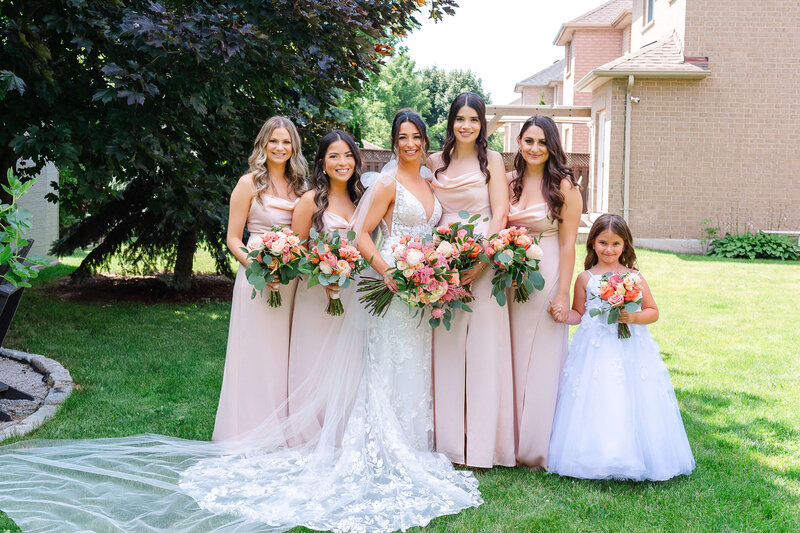 a full length photo of a bride and her bridesmaids and flower girl.  Captured outdoors by Ottawa wedding photographer JEMMAN Photography