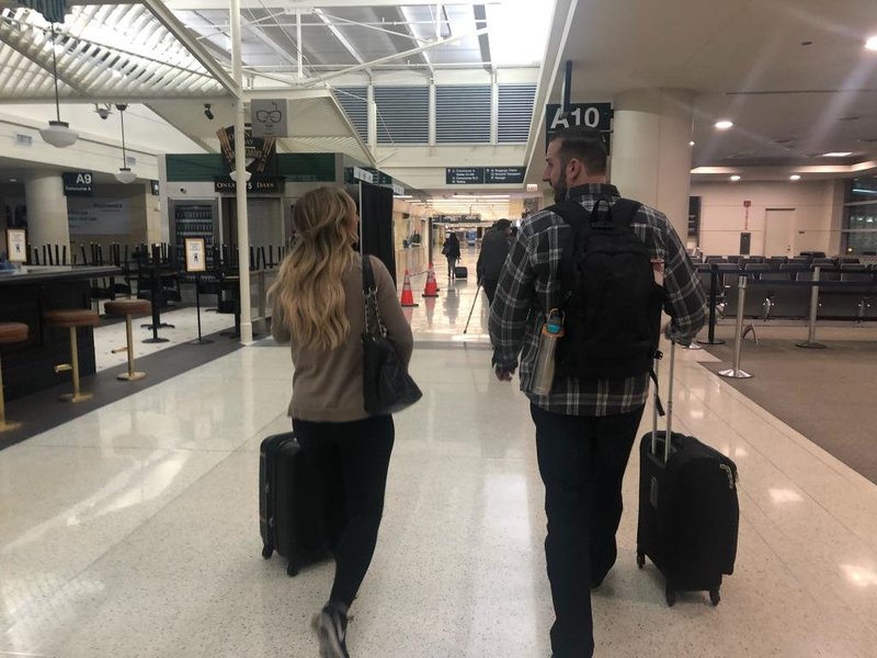 man and woman walking through airport