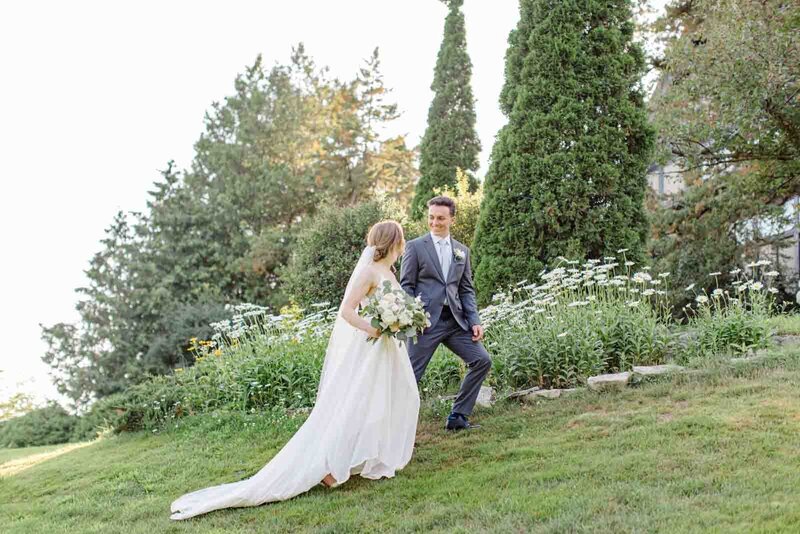 Grey Loft Studio - Bethany and Luc Barette - Wedding Photography Wedding Videography Ottawa - Emily and Methieu - bride and groom walking outside by wildflowers up hill