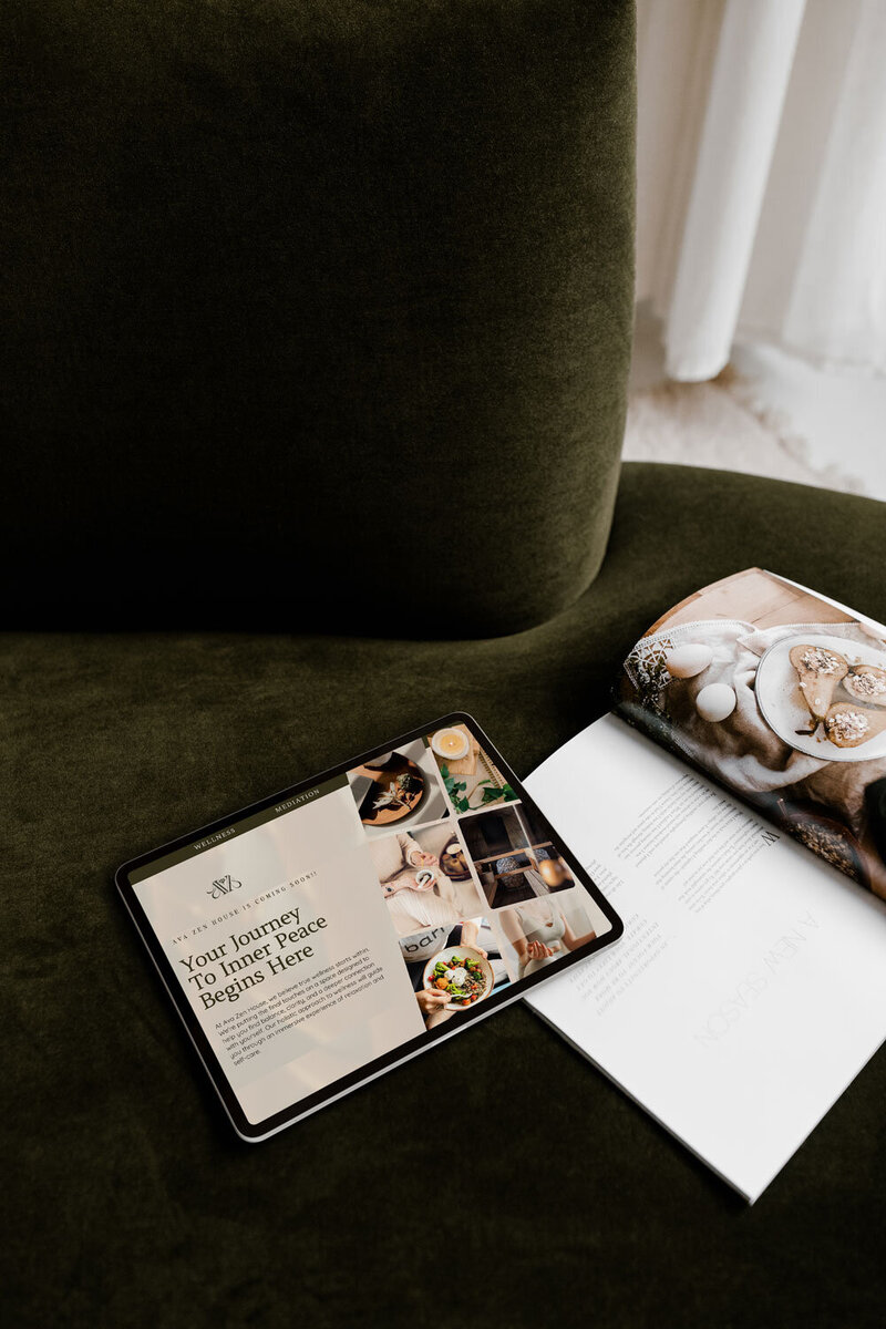 tablet on a cozy gray couch displaying a modern website design for soul-led women entrepreneurs.