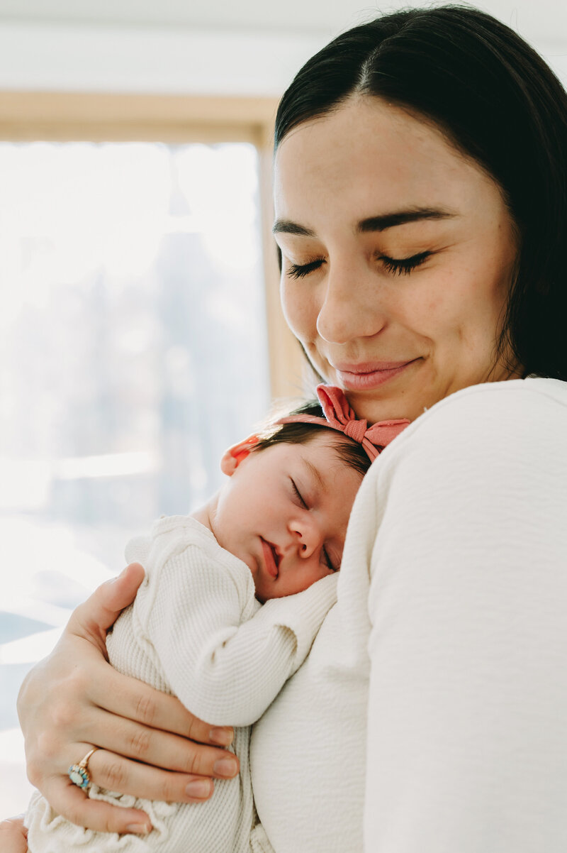 new mom holding her baby girl in her Arlington, VA home
