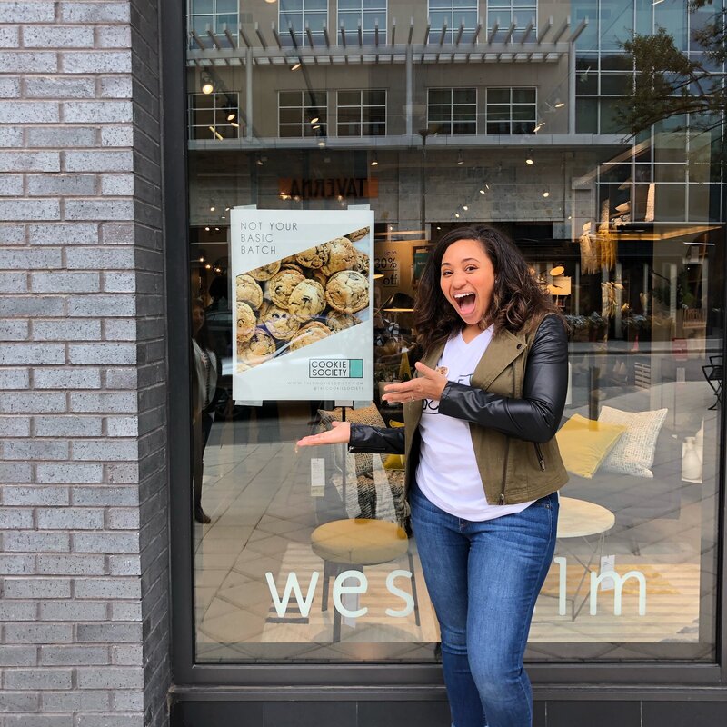 Marissa showcasing business signage in front of store