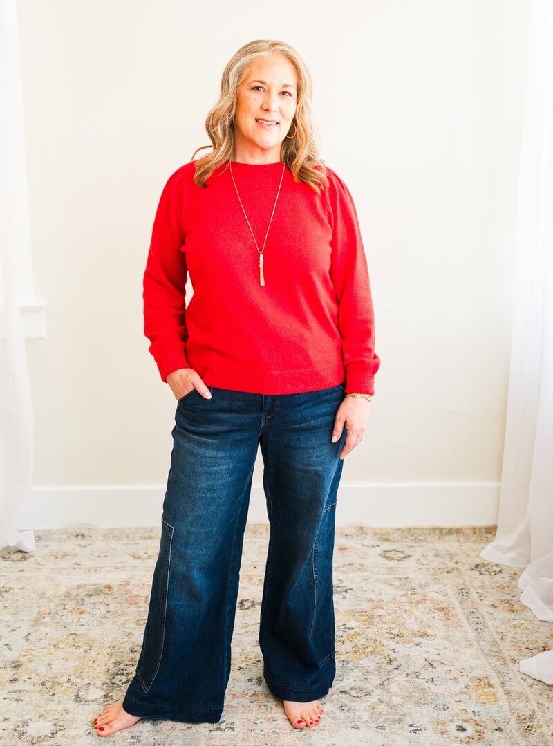 Woman in a red sweater and jeans.