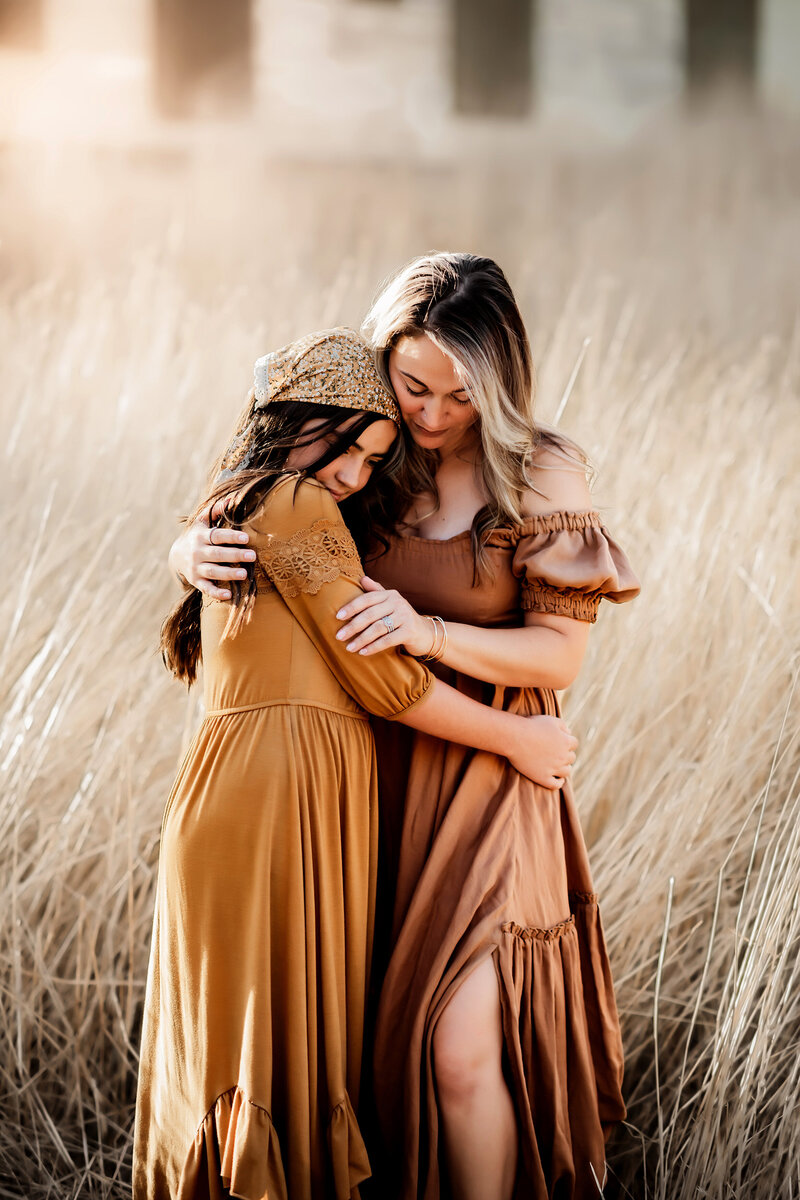 Mom holding daugher in grassy field at Viestenz-Smith Mountain Park Colorado
