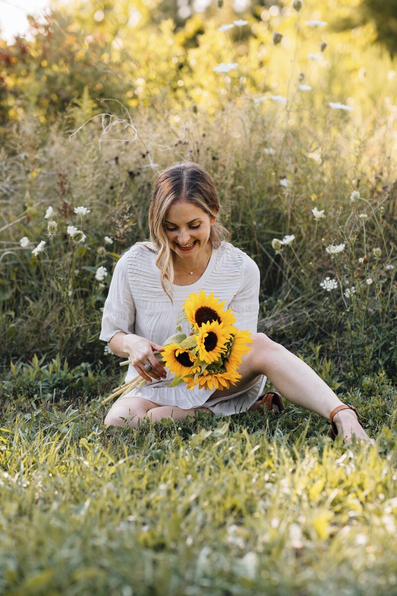 woman in a field with sunflowers laughing