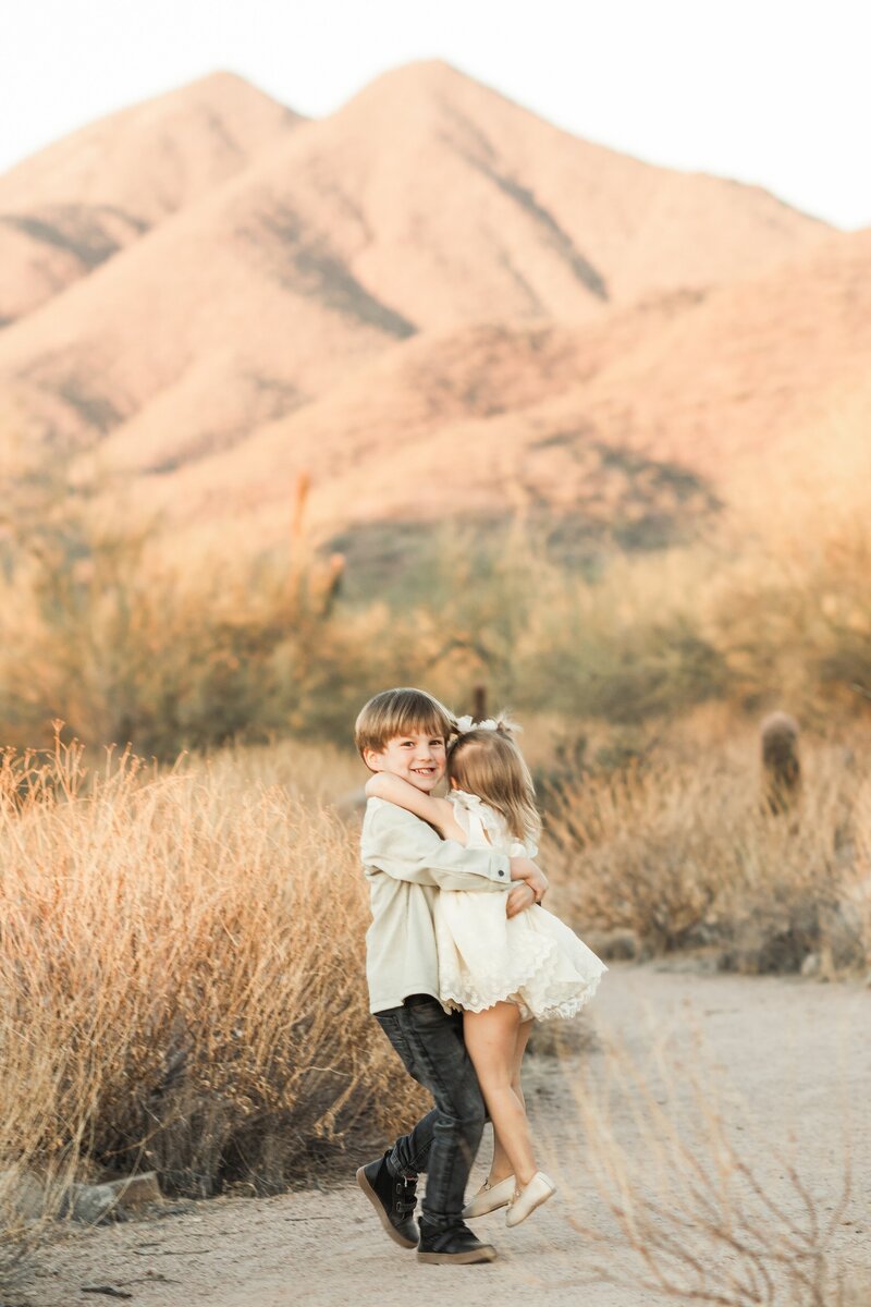 brother and sister hugging in the north scottsdale desert