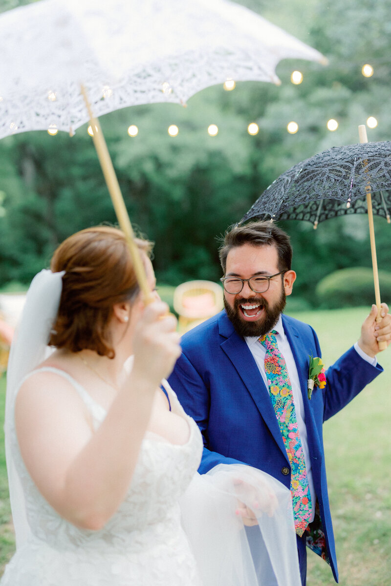 bride and groom under umbrellas