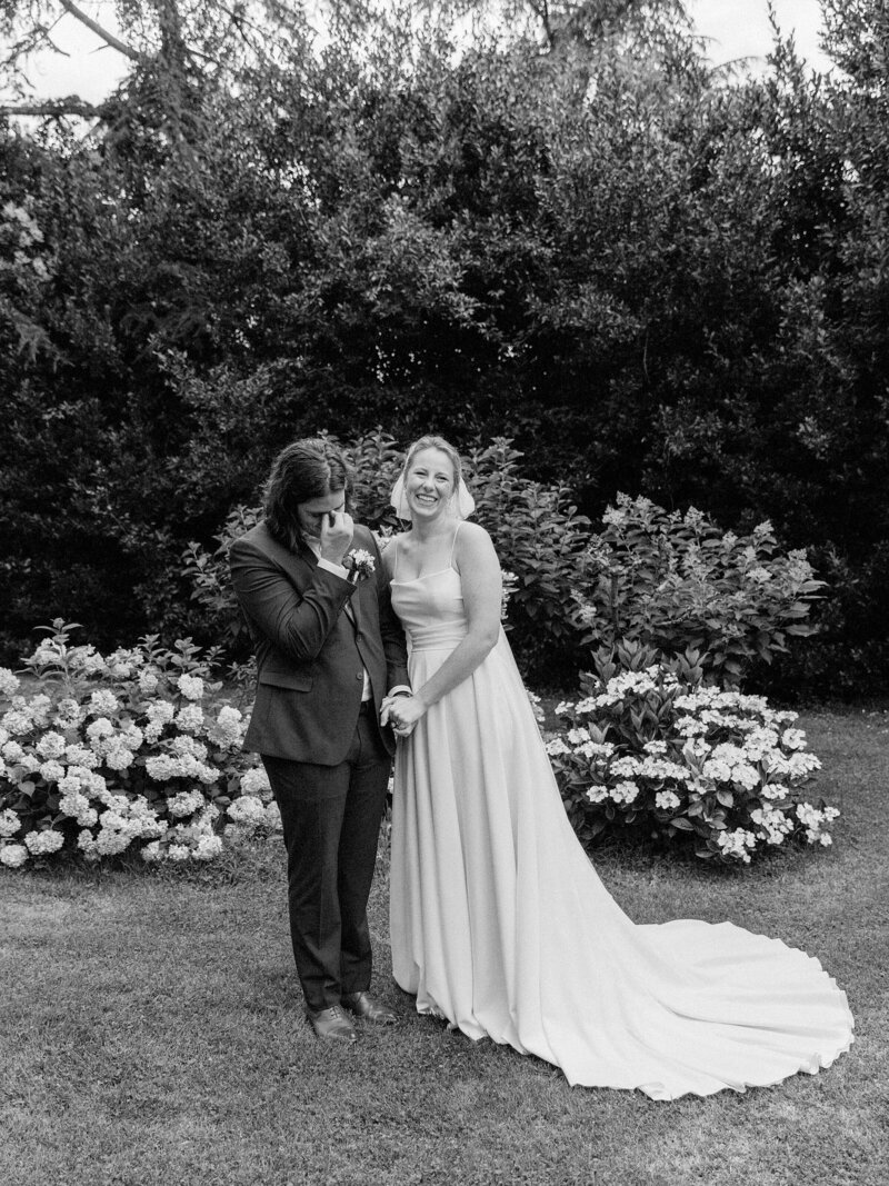 Groom kisses brides cheek making her laugh