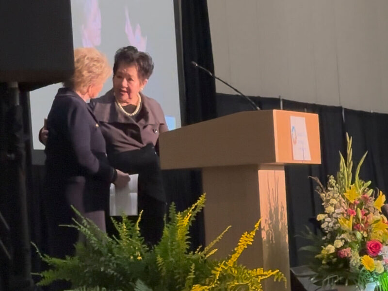 Nita Tin wearing a blue dress, smiling into the camera as a guest on the Women’s World Leaders Podcast, Empowering Lives with Purpose, hosted by Kimberly Hobbs.