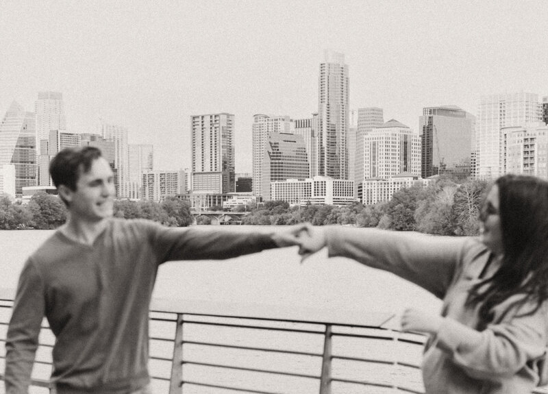 Newly Engaged couple wearing casual clothes dancing next to Lady Bird Lake near downtown Austin. Engagement photo by photographer in Austin | Photos by Meggie