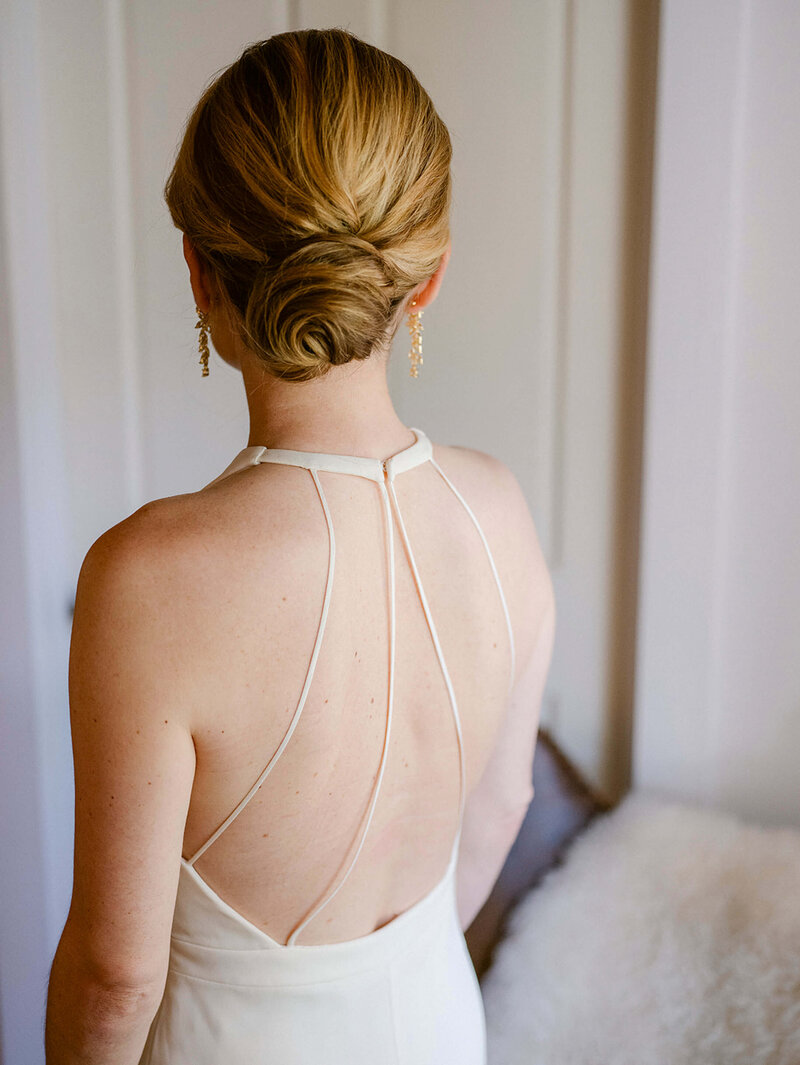 bride from the back with a beautiful open back gown and a sleek bun