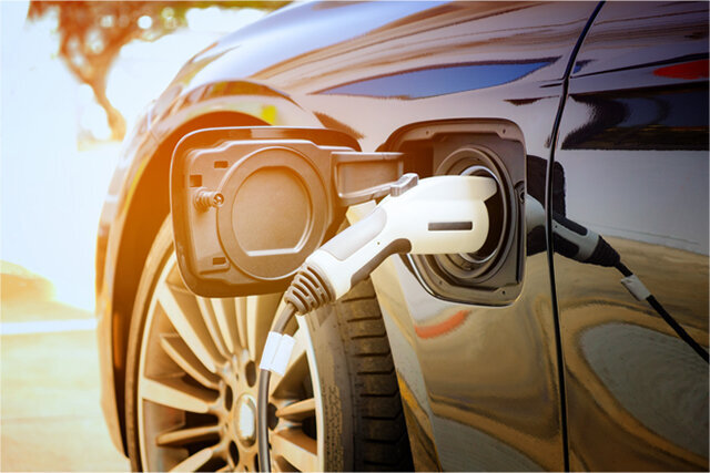 black electric vehicle charging on sunny day