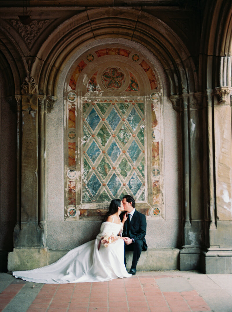 Bride and groom sharing a romantic kiss during their elegant elopement at Bethesda Terrace in New York City, captured by Stephanie Michelle Photography, a luxury wedding photographer