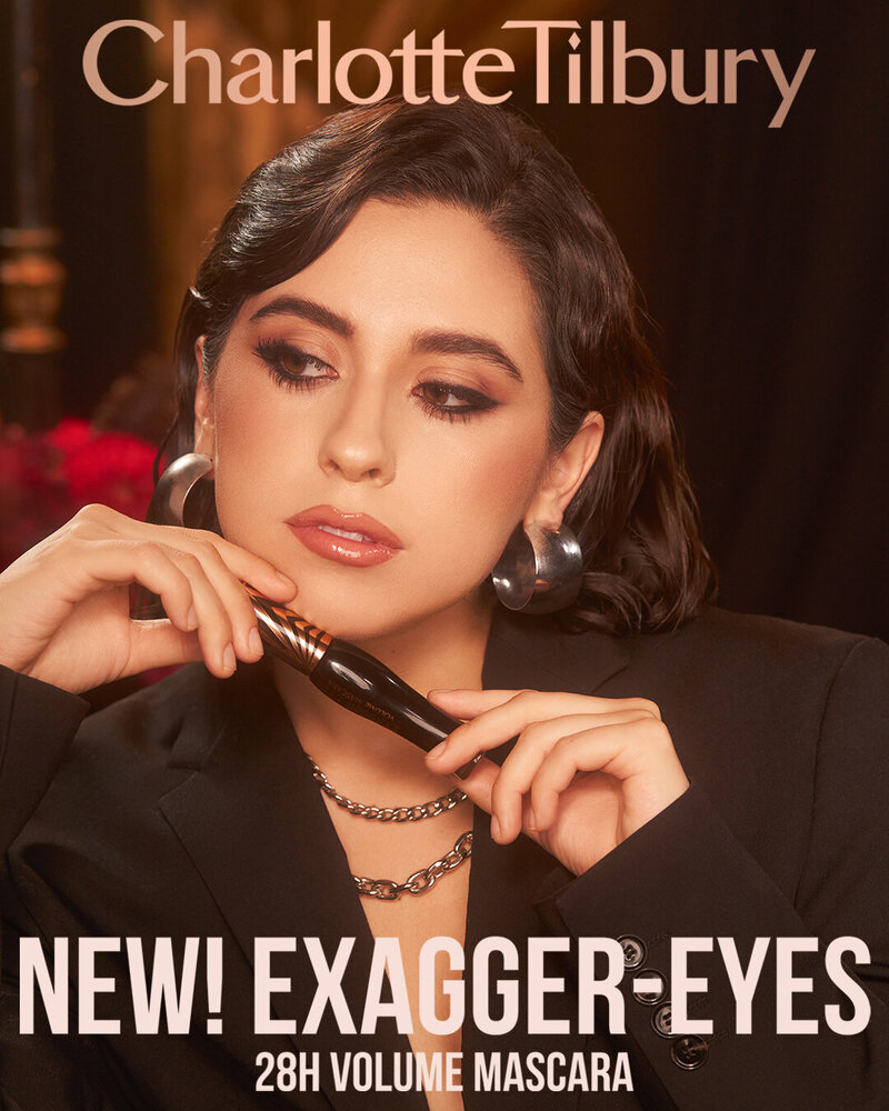 Charlotte Tilbury Exagger-Eyes 28H Volume Mascara campaign featuring Elizabeth Villalobo, holding the mascara in a glamorous setting with elegant makeup.