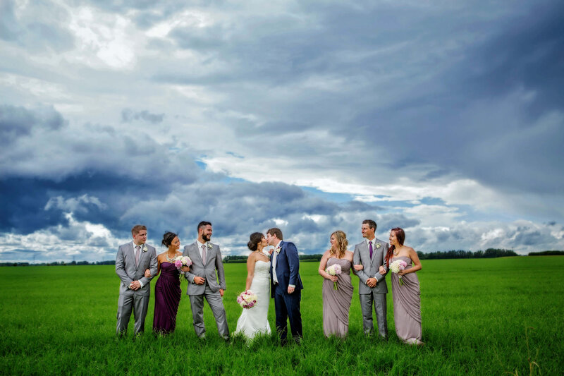 wedding party in vibrant grass and moody sky
