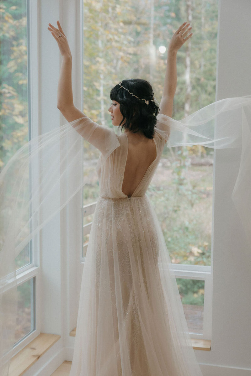 Bride twirling near large windows, veil flowing in the air