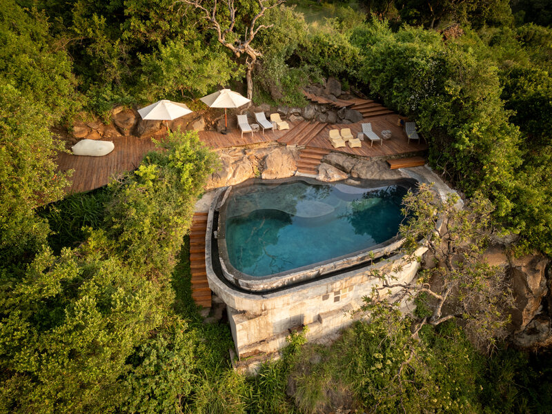 Luxury cliffside infinity pool surrounded by tropical greenery, ideal for wellness and restorative escapes.