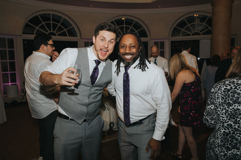DJ Marz smiling with a guest on the dance floor at an indoor Chicago wedding reception, capturing a fun and memorable moment during the celebration.
