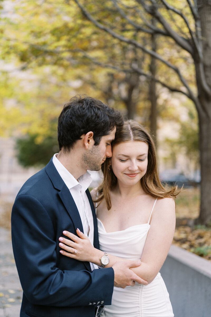 Couple sharing intimate moment while embracing  in outdoor fall setting.