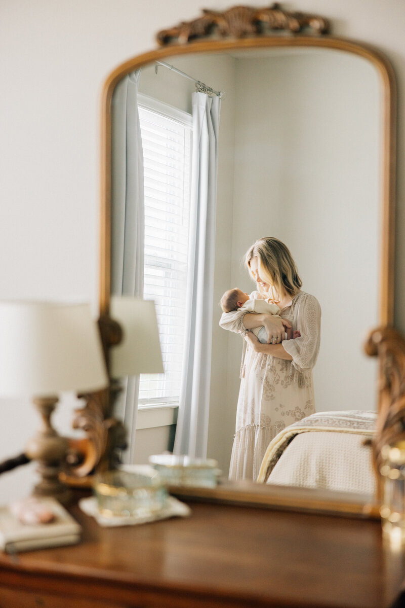 Mother gazes at newborn child in mirror