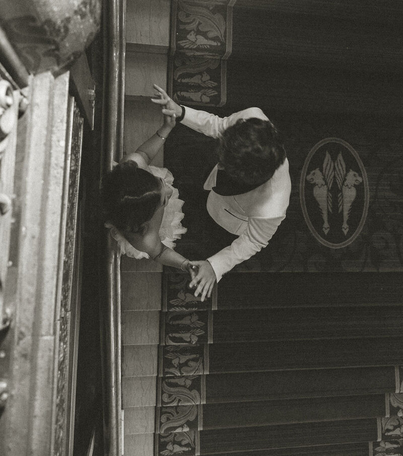 A couple holding hands on a staircase