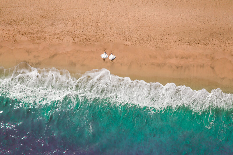 couple in hawaii holding hands on beach drone videography