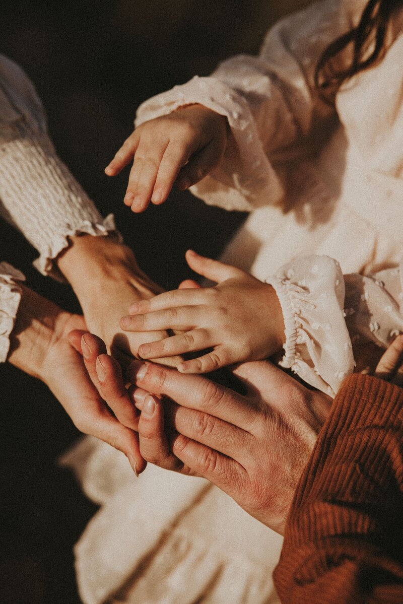 Family session, hands on top of another, mother, father, children, holding hands