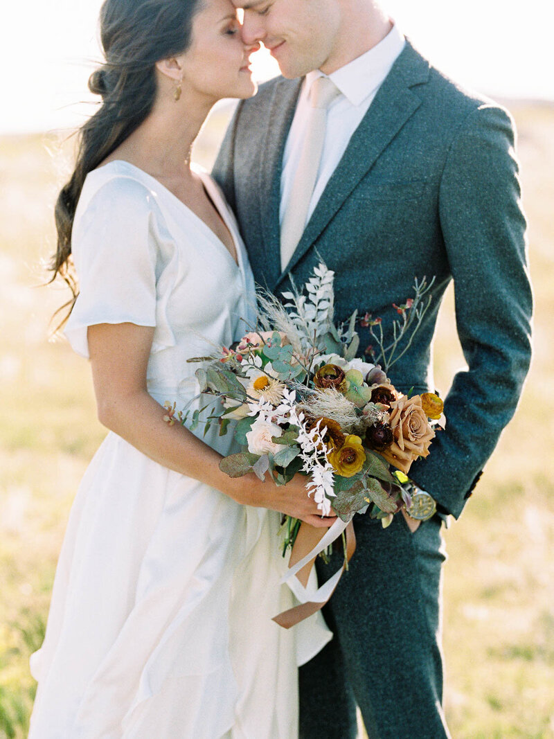 Couple almost kissing holding flowers